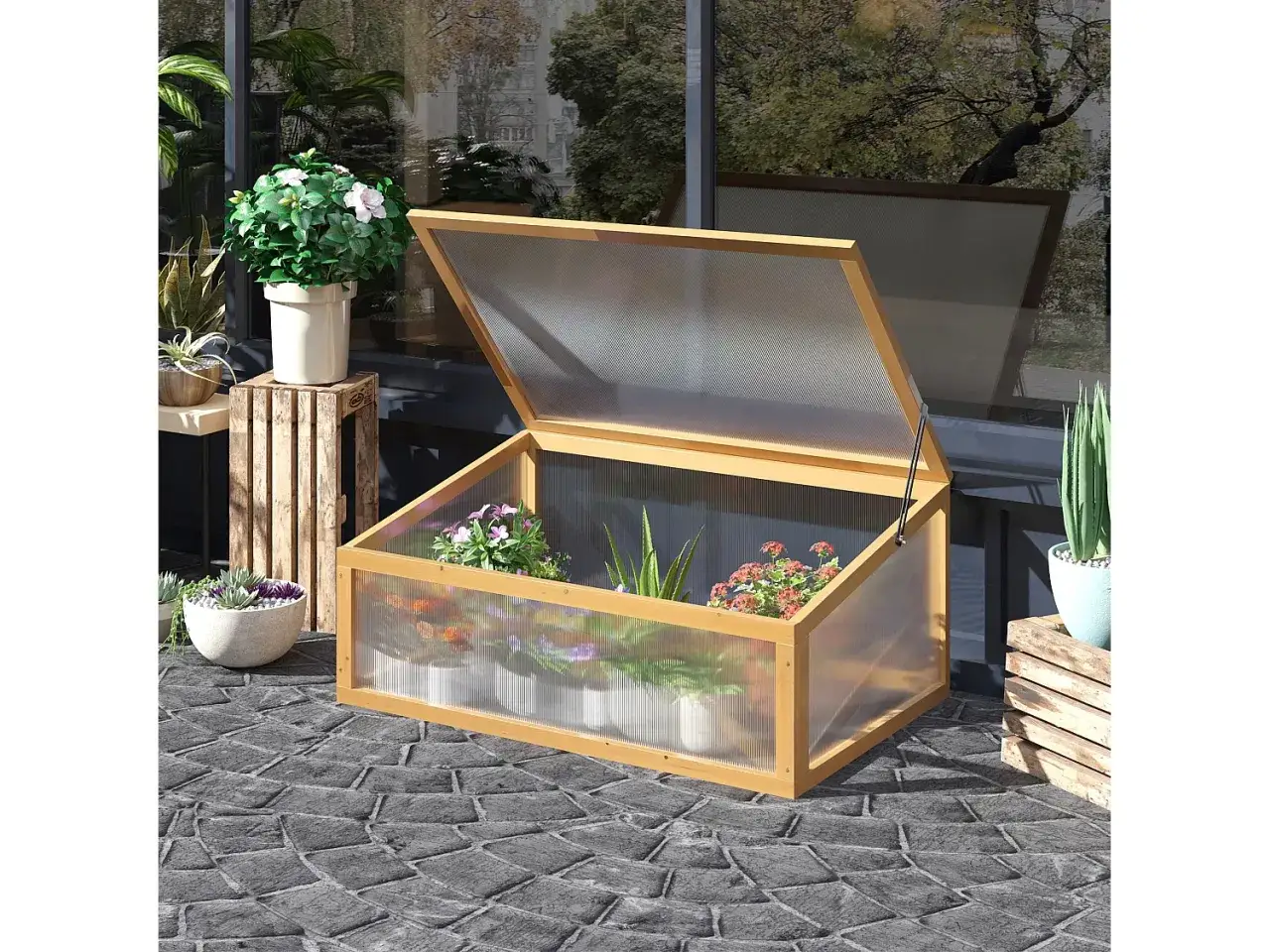 Une serre en bois avec un couvercle ouvert, idéale pour apprendre comment fabriquer toit pour tomates. Elle abrite des plantes en pot.